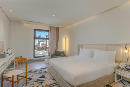 a bedroom with a large white bed and a living room at Ewaa Express Hotel - Al Shati in Jeddah