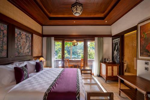 sypialnia z dużym łóżkiem i stołem w obiekcie Puri Saraswati Dijiwa Ubud w mieście Ubud