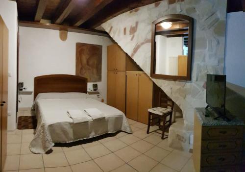 ein Schlafzimmer mit einem Bett und einer Steinmauer in der Unterkunft Appartamento La Grotta in Vicenza