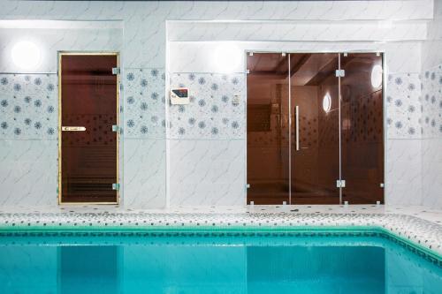 a bathroom with a swimming pool and a shower at Manifa Hotel in Tashkent