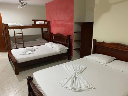 two beds in a room with two bunk beds at Hotel Villa Grant in Aguachica