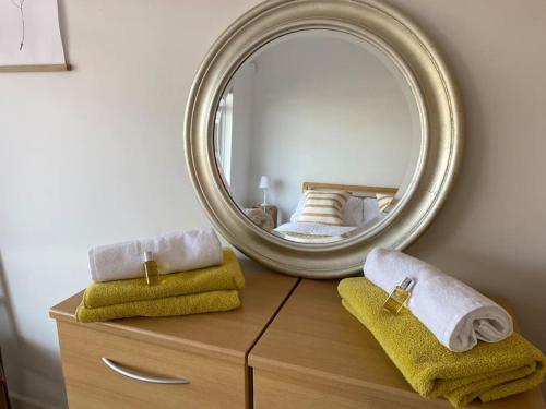 bagno con specchio e cassettiera con asciugamani di Modern holiday home with sea view- close to beach a Portstewart