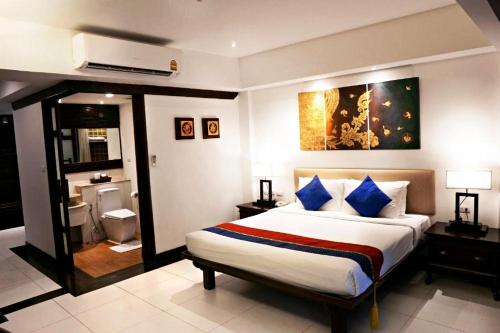 a bedroom with a large bed and a bathroom at Yantarasri Resort in Chiang Mai