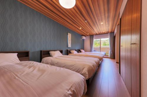 a row of four beds in a room at Glamping Cottage Kawaguchiko in Fujikawaguchiko