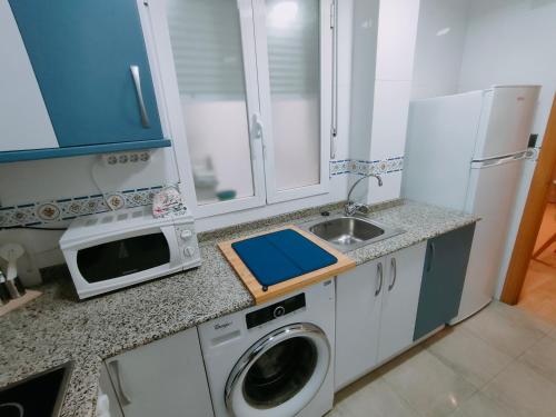 a kitchen with a washing machine and a sink at Tirwal Suite San Juan in Teruel