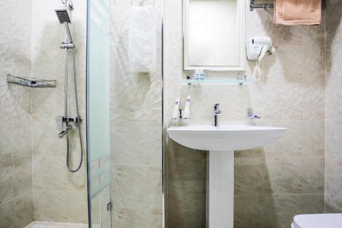 ein Bad mit einem Waschbecken und einer Dusche in der Unterkunft Manifa Hotel in Taschkent