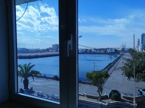 a window with a view of a body of water at Hotel El Layeli in Sfax