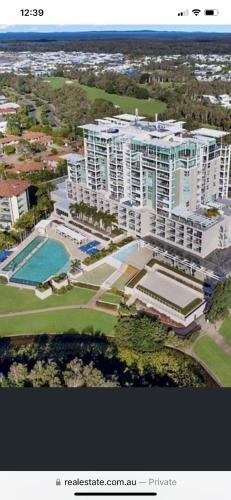 an aerial view of a large apartment building with a pool at Pelican Waters Resort One Bedroom Apartment in Pelican Waters