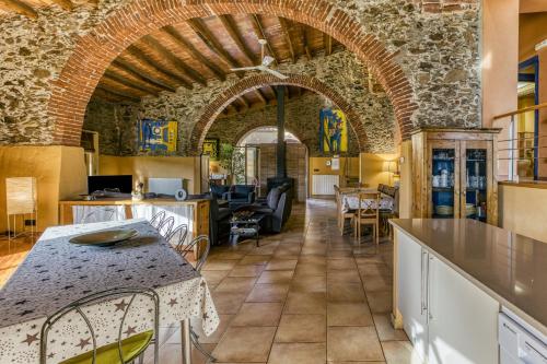 cocina y comedor con pared de piedra en Rural Mas Hortus, en Girona