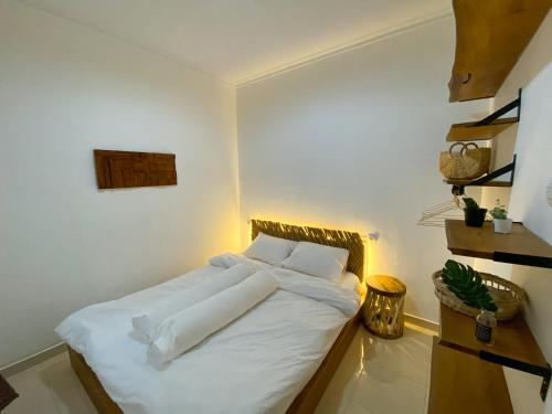 - une chambre avec un lit doté de draps et d'oreillers blancs dans l'établissement Casa Tartu - Modern Rustic Family Home, à Ngaglik