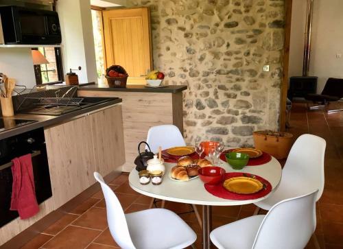 una mesa con un plato de comida en la cocina en Le moulin du Rubeguet, en Saint-Julien-de-Cassagnas