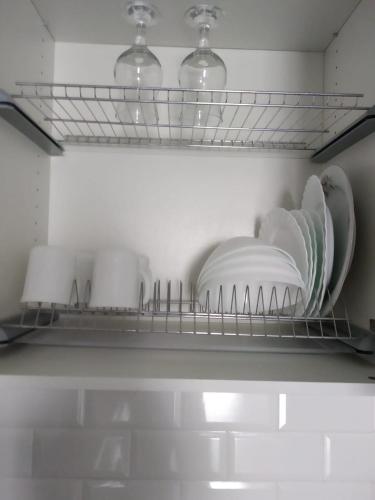 ein Regal mit Tellern und Geschirr in einem Kühlschrank in der Unterkunft Молодежный in Almaty