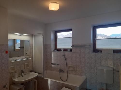 ein Badezimmer mit Badewanne, Waschbecken und Dusche in der Unterkunft Vintage Apartment Bled in Bled