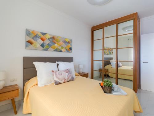 1 dormitorio con 1 cama con colcha amarilla en Mogan Beach Blue Sky, en Mogán