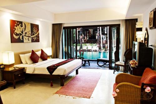a bedroom with a bed and a view of a pool at Yantarasri Resort in Chiang Mai