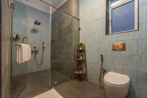 a bathroom with a shower stall and a toilet at SaffronStays Mariposa by the River Rio, Karjat in Karjat