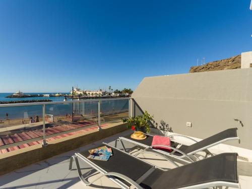 a balcony with chairs and a view of the beach at Mogan Beach Blue Sky in Mogán