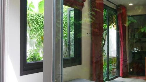 a room with two windows with red curtains at Cửa Biển Homestay in Hai Phong