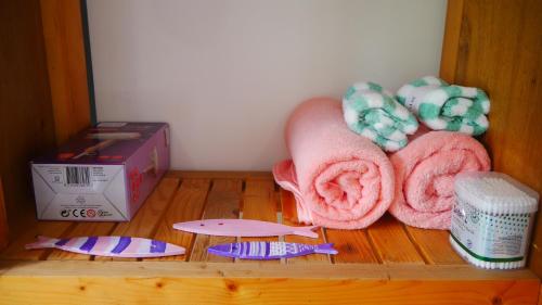 a shelf with towels and a box on a wooden floor at Cửa Biển Homestay in Hai Phong