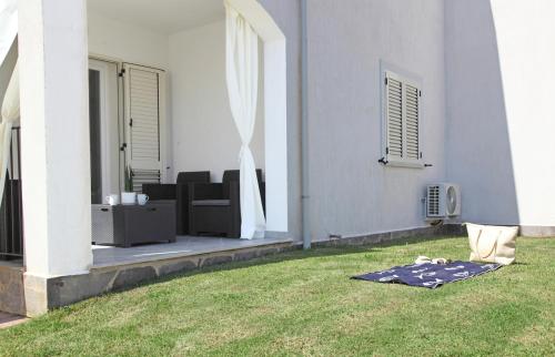 een deken op het gras naast een huis bij Casa Bianca Marea in Santa Maria Navarrese