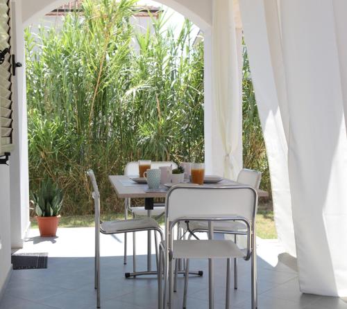 een tafel en stoelen op een veranda met een tafel en stoelen bij Casa Bianca Marea in Santa Maria Navarrese