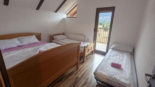 Cette petite chambre comprend 2 lits et une fenêtre. dans l'établissement Vikendica Pašter, à Šipovo