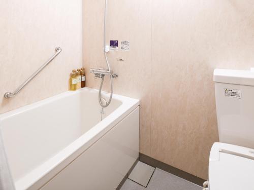 a bathroom with a bath tub and a toilet at Vessel Hotel Kanda Kitakyushu Airport in Kanda