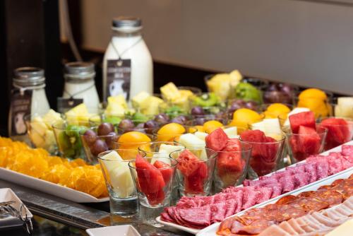 a buffet filled with different types of fruit in cups at Meliá de Tredós in Tredós