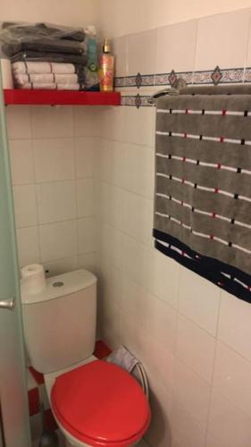 La salle de bains est pourvue de toilettes rouges et d'un couvercle rouge. dans l'établissement Mazet provencal au coeur des Alpilles La Rêverie, à Maussane-les-Alpilles