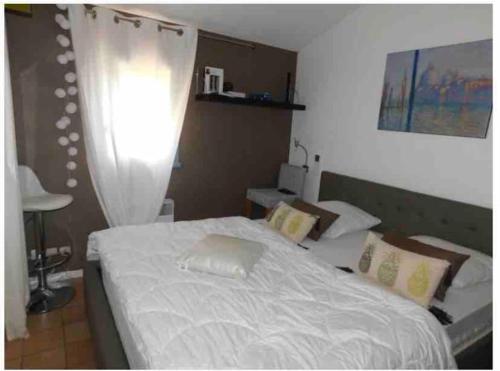 una camera con letto bianco con tenda di Mazet provencal au coeur des Alpilles La Rêverie a Maussane-les-Alpilles