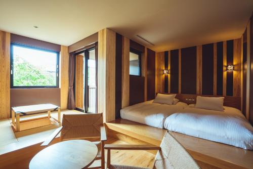 ein Schlafzimmer mit einem Bett und einem großen Fenster in der Unterkunft SETRE Naramachi セトレ ならまち in Nara