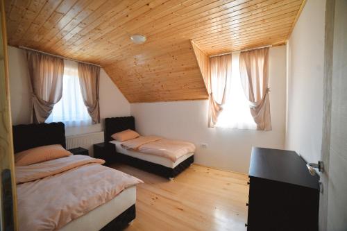 - une chambre avec 2 lits et 2 fenêtres dans l'établissement Vila Pavle, à Bajina Bašta