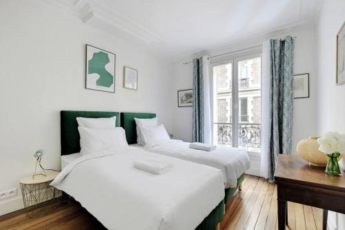 1 Schlafzimmer mit 2 Betten und einem Fenster in der Unterkunft GemBnB Luxury Apartments - Residence Leon Jost in Paris