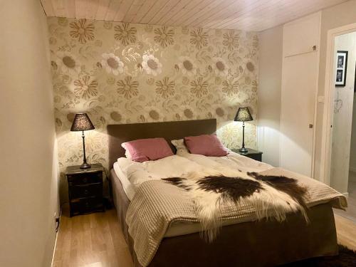 Un dormitorio con una cama con almohadas rosas. en Utmelandsvägen 41 Helt hus, en Mora