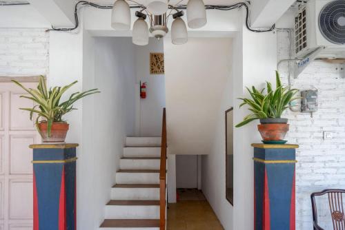 a hallway with two blue and red columns with potted plants at RedDoorz Syariah near Plengkung Gading 2 in Yogyakarta