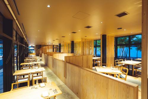 un restaurante con mesas y sillas de madera y ventanas en SETRE Naramachi セトレ ならまち en Nara