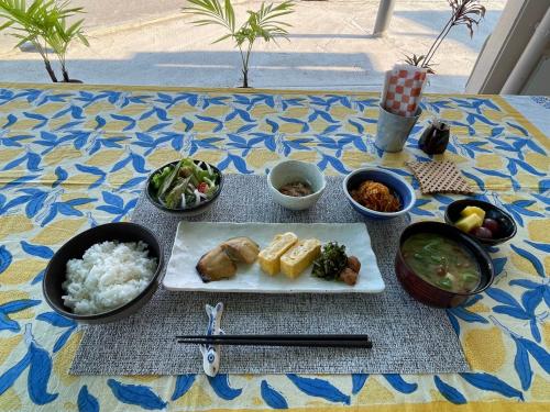 a table with a plate of food and bowls of food at Dining & Stay 38 Miyahira in Zamami