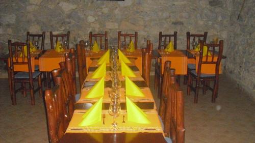 un comedor con mesas y sillas con servilletas amarillas en Penzion u Balcarky, en Ostrov u Macochy