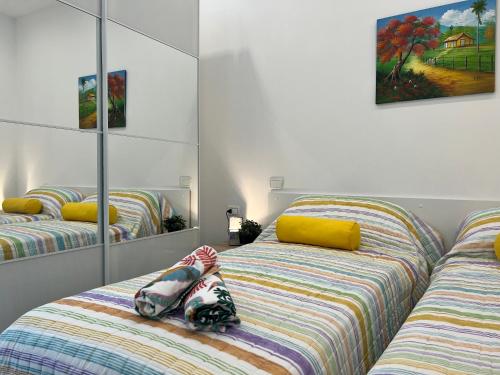 ein Schlafzimmer mit zwei Betten und einem Spiegel in der Unterkunft Bnbook Monolocale Gandhi in Rho