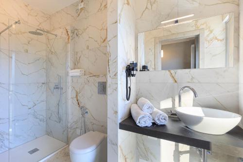 La salle de bains est pourvue d'un lavabo, de toilettes et d'un miroir. dans l'établissement Maravilla - By Impero House, à Baveno