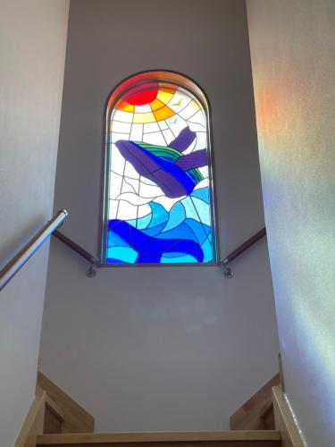 a stained glass window on the side of a staircase at Dining & Stay 38 Miyahira in Zamami