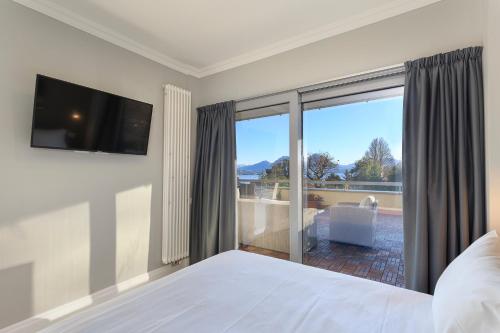 a bedroom with a bed and a sliding glass door at Maravilla - By Impero House in Baveno