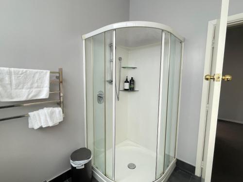 a shower with a glass door in a bathroom at Central Petone, lovely 4 bedroom in Lower Hutt