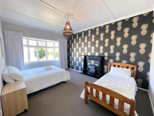 a bedroom with two beds and a fireplace at Central Petone, lovely 4 bedroom in Lower Hutt