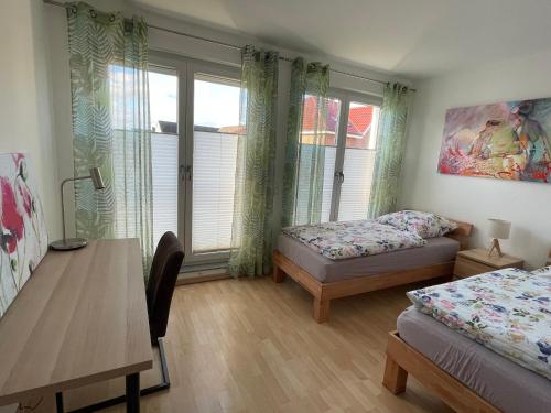 1 Schlafzimmer mit 2 Betten, einem Tisch und einem Schreibtisch in der Unterkunft Helle Wohnung mit Balkon 120qm, 4Zimmer in Dortmund