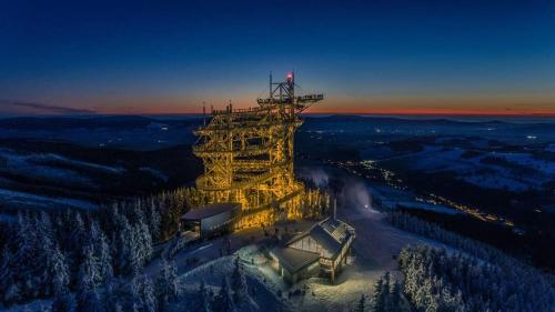 a large tower in the middle of a snow covered forest at Wellness chalupa Šindelka in Králíky