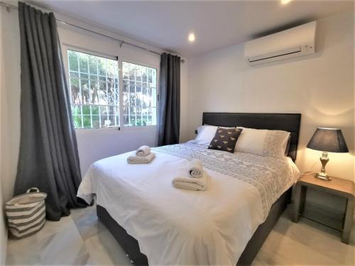 1 dormitorio con 1 cama grande y toallas. en Playa Lucera - ground floor apartment with sea views CS126, en Sitio de Calahonda