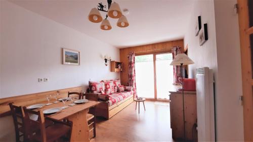 a living room with a table and a couch at Appt T2 Cabine 4-6 personnes au pied des pistes in Orcières