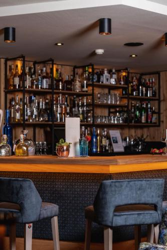 a bar with two chairs in front of a counter at Hotel Sun Valley in Selva di Val Gardena