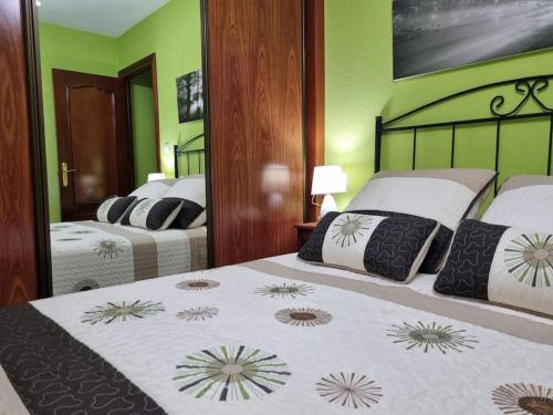 een hotelkamer met 2 bedden en een spiegel bij 126B Apto Playa - 3 Habitaciones in Gijón